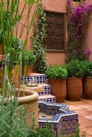 Mentha en pots en terre cuite dans une cour de style marocain et fontaine carrelée dans le jardin SPANA Courtyard Refuge - RHS Chelsea Flower Show 2008
