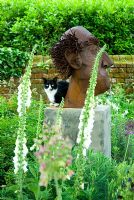 Fangle le chat de la famille sur la sculpture de Paul Richardshon avec Digitalis en premier plan