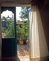 Vue à travers les portes-fenêtres du jardin potager en été