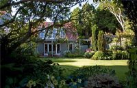 Jardin de campagne avec pelouse bien entretenue. Maison peinte en gris avec des tuiles en terre cuite. Christchurch, Nouvelle-Zélande