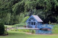 Piscine naturelle et parterres de filtres à roseaux dans le grand jardin de Londres avec pavillon d'été et pont