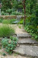 Jardin avant avec marches en pierre, chemin de gravier et siège. Sandhill Farm House, Hampshire.