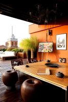 Terrasse avec coin salon contemporain avec canapés et murs peints en orange à Ferrare, Italie