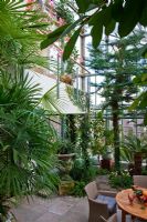 Vue de la véranda au deuxième étage, sécurisée par une balustrade moderne. La plantation comprend Araucaria heterophylla, Bougainvillea glabra, Citrus sinensis, Cycas revoluta, Ficus cyatistipula et Rhapis excelsa - Wintergarten, Allemagne