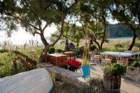 Patio dans le jardin côtier méditerranéen avec vieux bateau de pêche