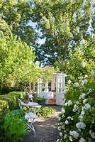 Rosa Mme plantier, maison d'été blanche, table et chaises blanches