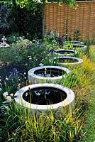 Rangée de pots en résine de fibre de verre comme mini étangs. Jardin de célébration et de jubilation. Hampton Court Palace Flower Show 2012