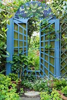 Miroir de jardin avec bordure peinte en bleu et peinture sur le thème 'Homme vert' en haut
