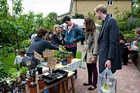 Les jeunes d'acheter des plantes de décrochage au King Henry's Walk Garden, lotissements de la communauté urbaine, London Borough of Islington, Royaume-Uni