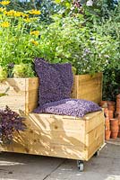 Pot mobile avec siège rembourré dans un petit jardin de banlieue