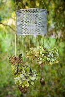 Carillon éolien fait maison avec des têtes de fleurs d'hortensia, des têtes de graines d'allium, des baies et des couverts en argent antique