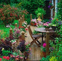 Jardin de banlieue coloré avec coin salon en bois recouvert de pots
