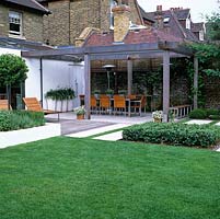 La terrasse en bois relie la maison au jardin avec un coin repas extérieur