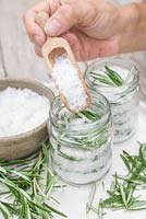 Dans des bocaux en verre, créez des couches de sel marin puis de feuilles de romarin jusqu'à ce que le bocal soit plein