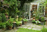En regardant à travers le jardin jusqu'au jardin d'hiver, où Susan Adcock est assise en train de travailler. Plantes incluses, White Petunia, Hostas, Clipped Box, Lilium Regale, Hebe et fougères.