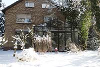 Vue sur la maison avec véranda et plantes architecturales couvertes de neige - Jardin Welsch, Berlin, Allemagne