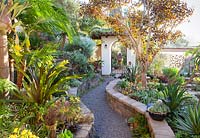 Chemin à travers les parterres de murs jusqu'à la passerelle. Jardin de Jim Bishop. San Diego, Californie, USA. Août.