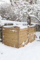 Bacs à compost en bois dans la neige