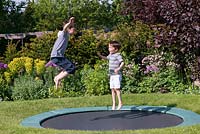 Oscar, Archie, 9 et 7 ans, sur le trampoline, s'est installé dans la pelouse.