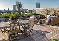 Table et chaises et coin salon sur une terrasse sur le toit de Londres. Avril.