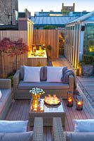 Coin salon extérieur donnant sur un espace barbecue au crépuscule sur une terrasse sur le toit de Londres. Avril.