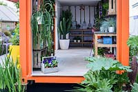 L'intérieur d'une caisse d'expédition orange utilisée comme hangar de mise en pot au RHS Greening Grey Britain pour la santé, le bonheur et l'horticulture. RHS Chelsea Flower Show 2016 - Designer: Annie-Marie Powell