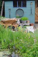 Étang de la faune du jardin avec cabanon en arrière-plan, UK, Mai