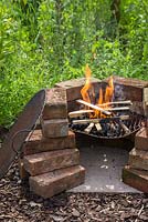 Un barbecue fait maison avec un feu sur le pouce
