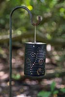 Une lanterne de boîte de conserve allumée peinte en noir