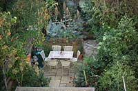 Jardin arrière urbain avec mobilier de jardin, dallage, chauffe-terrasse et dallage