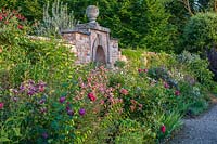 Jardin potager clos Lilium speciosum 'Black Beauty' et Clematis viticella 'Emilia Plater' - Morton Hall Gardens, Worcestershire