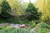 Sculpture en métal sur dallage en pierre naturelle et piscine avec Salix alba 'Tristis' et Iris 'Carnival Time' - The Wedgwood Garden - RHS Chelsea Flower Show 2018