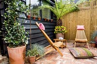 London patio garden avec pergola, bureau de jardin en bois, plantation mixte et chaises de jardin en bois