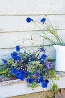 Bouquet de bleuets, ammi visnaga, eryngium et lupins sur banc