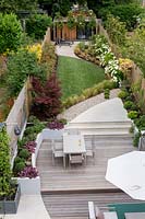 Vue élevée du jardin contemporain avec terrasse en bois et terrasse en gazon artificiel Jardin contemporain à Dulwich