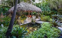 La cabane chickee et étang dans un jardin tropical. La résidence Jones, Key West, Floride, USA. Conception de jardin par Craig Reynolds.