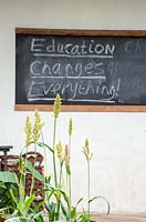 Tableau noir avec 'L'éducation change tout' - Le jardin Camfed: Donner aux filles en Afrique un espace pour grandir, RHS Chelsea Flower Show 2019.