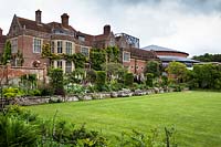 Parterres de printemps mixtes bordant la pelouse devant la maison de Glyndebourne