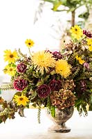 Pot d'Anduze avec arrangement floral, avec Dianthus 'Minerva', Helianthus tuberosus, Chrysanthemum 'Anastasia Sunny', Hydrangea, Coleus et Phytolacca.