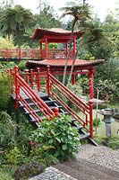 Jardin d'inspiration orientale inférieur avec marches, main courante et point de vue avec boiseries peintes en rouge