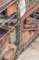 Close up detail de cage de gabion remplie de tuiles, de tuyaux et de briques