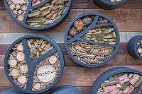 Hôtels à insectes circulaires fixés à un mur en bois et remplis de cannes de bambou, de têtes de semis, de branches, de pierres et de mousse. Le jardin sur le toit de l'Eau Bleue RBC commandité par la Banque Royale du Canada