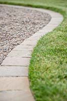 Bordure de chemin en pavés carrés, bordure entre pelouse et chemin de gravier.