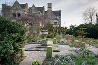 Le jardin de loisirs avec une urne en pierre et une boîte coupée panachée en son centre, Rodmarton Manor, Glos, Royaume-Uni.