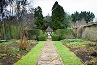 Un chemin mène vers la maison d'été entre les parterres herbacés à Rodmarton Manor, Glos, UK.