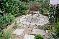 Pavage circulaire avec Acer plantés au centre - Érable, en premier plan des pierres de gué et plantation en gravier