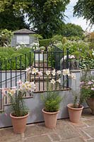 Vue jusqu'au jardin en forte pente avec des marches et des balustrades en pierre et des parterres de fleurs et un pavillon d'été au-delà, Cheshire