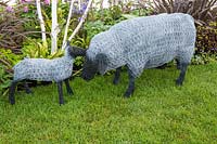 Sculptures de fil de poulet d'un mouton et de l'agneau sur une pelouse. Jardin des joyaux cachés du Worcestershire, RHS Malvern Spring Festival, 2016. Conception: Nikki Hollier