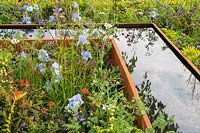 Abreuvoir en acier corten dans un parterre de fleurs herbacées mixtes. Le jardin UCARE, RHS Malvern Spring Festival, 2016. Designer Emily Sharpe