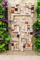 Un mur végétal de jardinage vertical et une clôture en bois moderne faite de vieux bois coupés. Pour l'amour de celui-ci, RHS Tatton Park Flower Show, 2017. Jardin Designer: Pip Prober